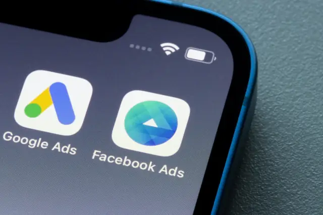 Close-up of a smartphone home screen showing the Google Ads and Facebook Ads app icons side by side